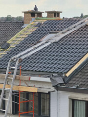 Ouvriers qui rénovent la toiture d’une maison pour isolation et remplacement des tuiles © joef
