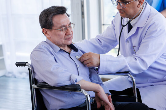 Medicine doctor is holding a stethoscope to examine Asian a man Mid-adult a patient and discussing health treatment sitting in the office at the desk. Medicine and health care concept.