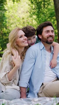 Cheerful family sits on grass enjoying spectacular surroundings
