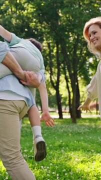 Caring mother and father laugh happily as run with son on back