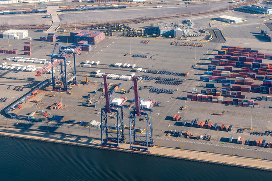 Staten Island, New York, USA - February 4, 2024 - Aerial view of container gantry cranes and stacked shipping containers at the Howland Hook Marine Terminal
