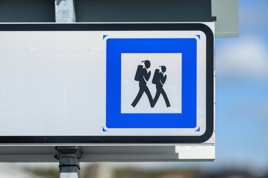 Blue school crossing traffic sign with walking children symbol.