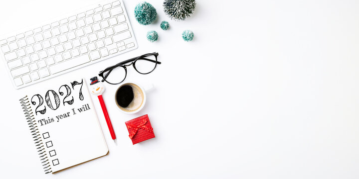 New year resolutions 2027 on desk. 2027 goals list with notebook, coffee cup, keyboard on white background. Resolutions, plan, goals, action, checklist, holidays concept. New Year 2027 resolutions