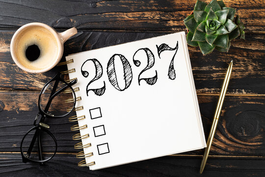 New year resolutions 2027 on desk. 2027 resolutions list with notebook, coffee cup on table. Goals, resolutions, plan, action, checklist concept. New Year 2027 template, copy space
