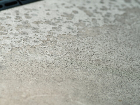 Weathered gray surface with organic spots and stains, minimal abstract stone texture background, natural aged pattern close-up