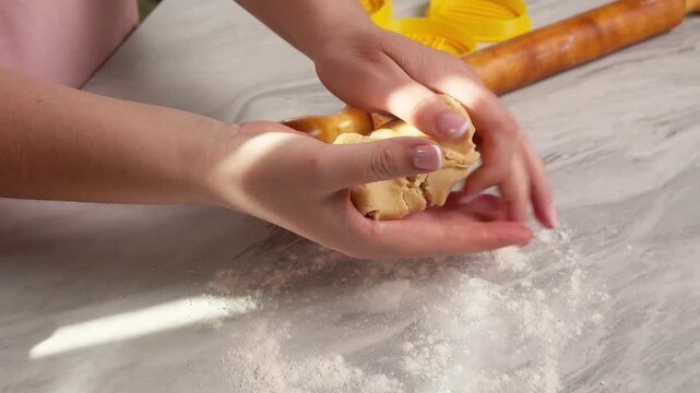 Hands Engaged in Crafting Dough on a Marble Surface with Flour and Kitchen Utensils Nearby