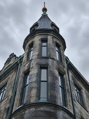 Fototapeta premium Slate-clad corner turret with a copper finial and narrow windows