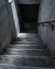 Fototapeta premium A concrete stairwell descending into a supply shelter with worn tread nosings