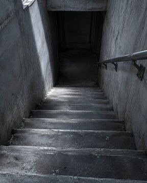 A concrete stairwell descending into a supply shelter with worn tread nosings
