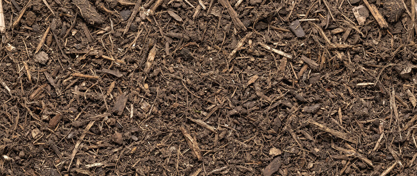 Fresh solid digestate fiber spread as a continuous earthy ultrawide material texture with coarse strands and natural irregularity