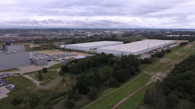 Aerial drone shot of modern logistics center and new car distribution terminal in industrial zone