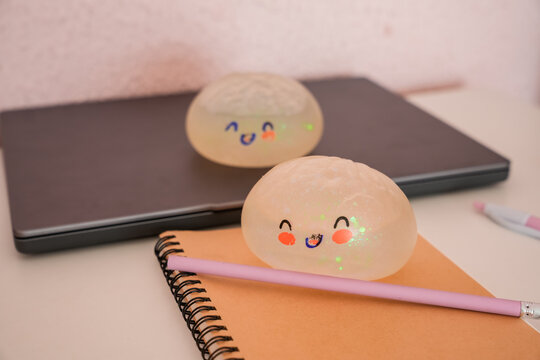 Two cute kawaii dumpling squish toys on desk with notebook and pencil