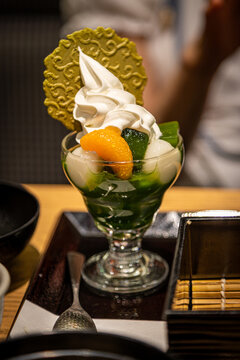 Matcha parfait, a Japanese sweet dessert made from green tea cultivated in Uji, Kyoto, with jelly, ice cream, dango mochi balls, fruits and wafer.