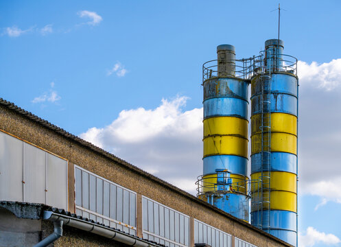 Old industrial silos at a weathered production facility under blue sky