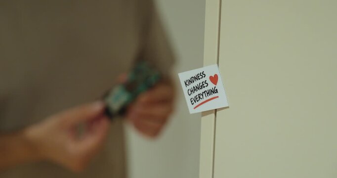 Inspirational note saying Kindness Changes Everything with a heart symbol and person in the background.