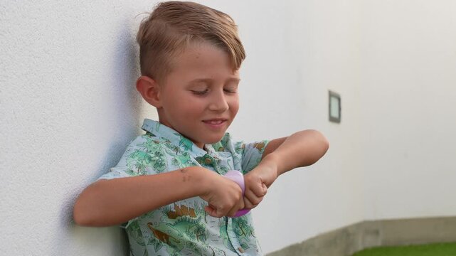 Smiling Boy Playing With a Pink Toy Outdoors