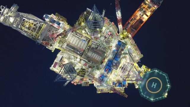 Aerial top view of offshore jack up rig and offshore platform during sunset for oil and gas exploration and production. 