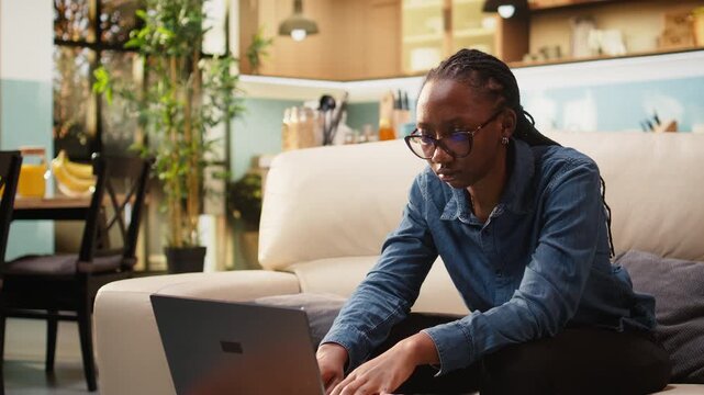Uncertain young woman frowns about ambiguous tasks while working remotely on laptop at home, confused about her telecommuting job indoors.