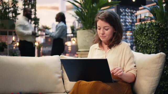 Businesswoman reads laptop information and takes notes