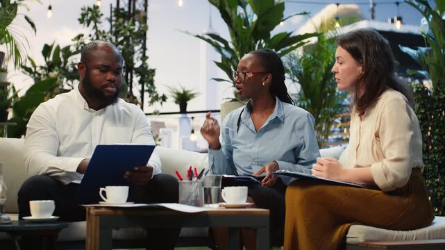 Businesswoman leads rooftop project discussion while taking notes