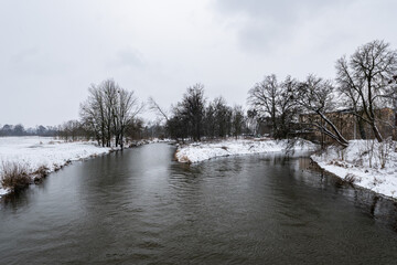 Zimowa panorama rzeki Osobłogi w popołudniowych godzinach pochmurnego szarego dnia w Zachodniej Polsce © mbugajsky