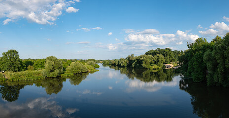 Panorama rzeki Odry w tle lekko pochmurna pogoda, błękit nieba zieleń przy brzegu, pora letnia, Odra w odcinku województwa Opolskiego © mbugajsky