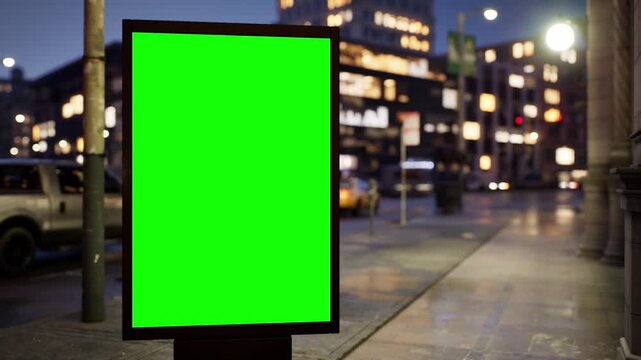 Blank green screen city light billboard on a downtown street in the evening blue hour with lit windows, clear sky. Timelapse of passing traffic with shallow depth of field and soft bokeh. Chroma key