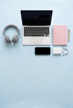 Vertical flat lay remote work kit with laptop and headphones