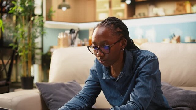 Young adult meditates and practices breathing exercises for stress relief while working remotely on laptop at home, eyes closed during a calm break.