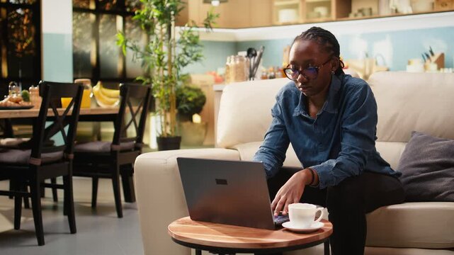 Young woman stretches muscles and relaxes at coffee table while remote work on laptop causes neck discomfort and stiffness from incorrect posture. She takes a break at home for work-life balance.
