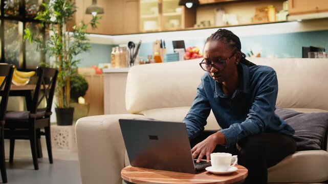 Distraught woman struggles with work mistake and failure, worried about a stressful crisis while working from home and feeling puzzled on sofa.