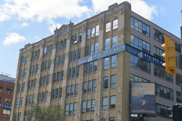 Obraz premium roadside billboard advertising a Volvo vehicle and facade of Fashion Building (126 Spadina Av) designed by Benjamin Brown and Kaplan & Sprachman, Toronto