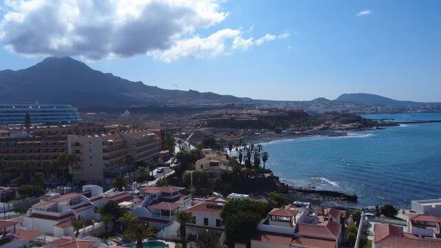 Vista a&eacute;rea de una carretera costera, hoteles y una playa de arena negra bajo el Roque del Conde, Costa Adeje, Tenerife