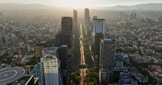 Mexico City Aerial v10 flyover iconic avenue at downtown with skyscrapers alongside and divine golden sunlight shinning on paseo de la reforma at sunset - Shot with Mavic 3 Cine - December 2021