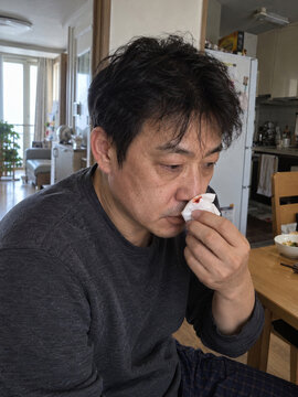 Man holding blood stained tissue during nosebleed