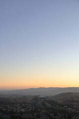 Fototapeta premium Crescent moon shines high above San Ramon valley at sunset