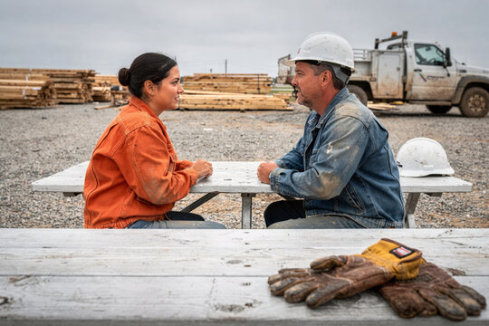 Construction Workers Talking at Picnic Table on Job Site