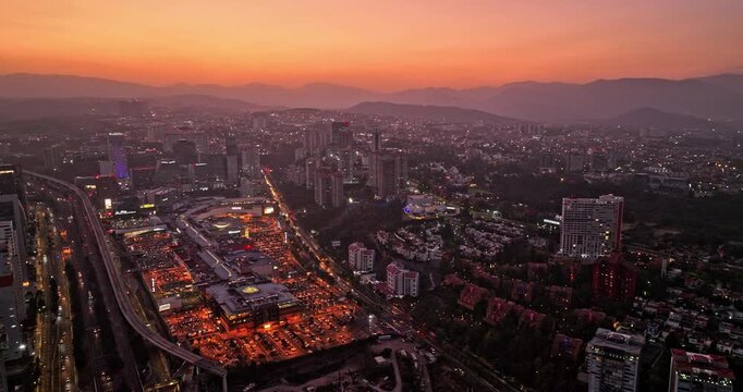 Mexico City Aerial v60 panoramic panning shot across Santa Fe neighborhood capturing illuminated urban cityscape with busy traffics during rush hour at dusk - Shot with Mavic 3 Cine - January 2022