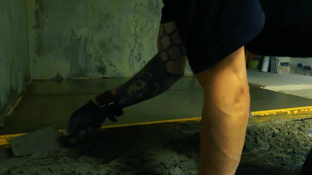 Professional builder installing a new cement screed floor during a home renovation, using a spirit level to carefully smooth and flatten the fresh mixture before it sets and hardens, timelapse