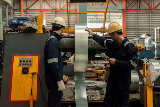 Engineers and staff are inspecting the assembly line system in a metal sheet and metal roofing manufacturing plant.