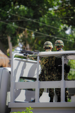 Mexican Military Patrol in Camouflage Uniforms Guarding on a Vehicle