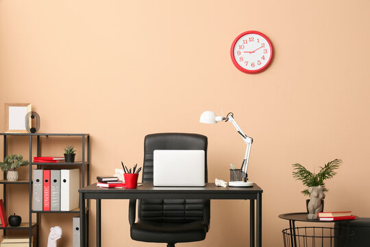 Remote work and deadline pressure, modern home office workspace with laptop and desk clock on beige wall for professional business productivity