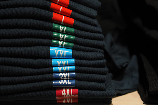 Stack of neatly folded t-shirts in various sizes after a retail display setup