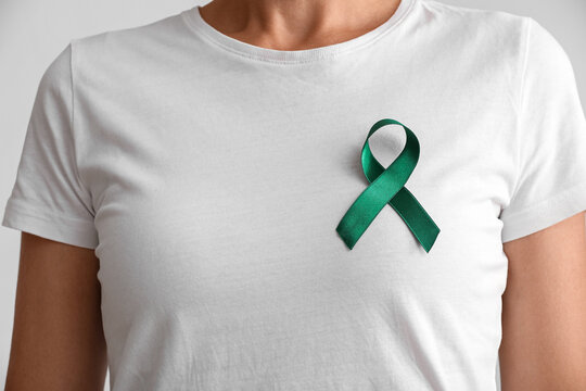 Mental health awareness and support, person wearing a green ribbon on a white t-shirt to promote wellness and advocacy for psychological well-being