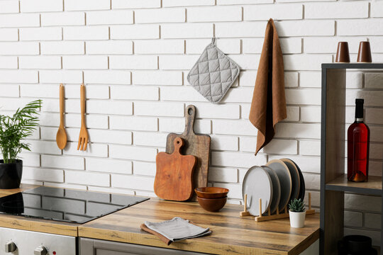 Home cooking and kitchen organization, modern culinary workspace with wooden cutting boards and ceramic plates on a rustic countertop against brick wall