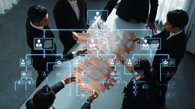 A diverse group of business professionals collaborate around a table, focusing on digital workflow concepts represented by wooden gears and data charts. Raster