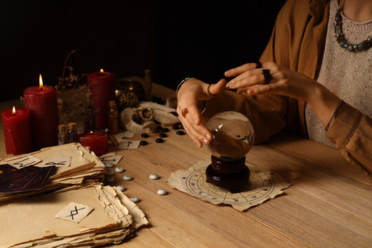 Fortune teller with crystal ball reading future  at table