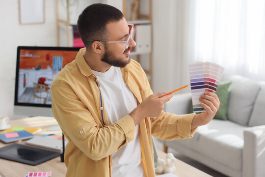 Male interior designer with color palettes in office