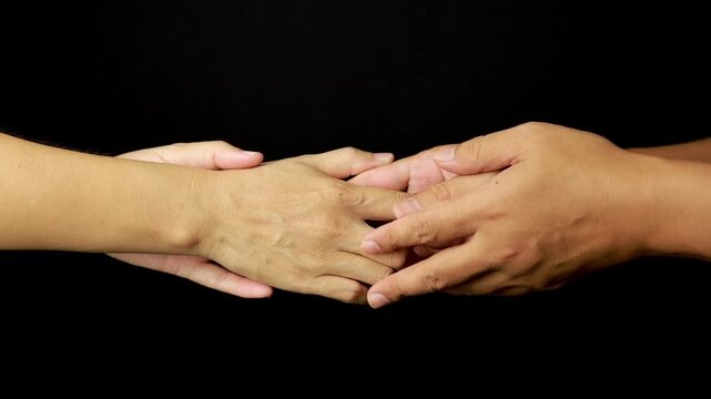 Slow Motion Close Up of Two Hands Slowly Letting Go and Separating on Black Background