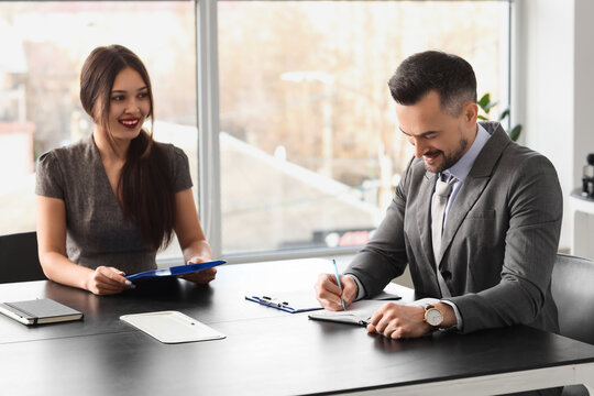 Human resources manager interviewing female applicant at table in office